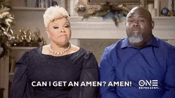 Reality TV gif. David and Tamela on the Manns sit next to each other in fancy clothes. David turns to his wife and says, “Can I get an Amen?” and see shakes her head, “Amen!” and he says back to her, “Amen!” she says it again while holding her fist up. Text, “Can I get an Amen? Amen!”