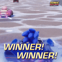 Sponsored gif. Sonic the Hedgehog uses one hand to balance in the air on the steering wheel of his race car as he drives. Text reads, “Winner! Winner!”