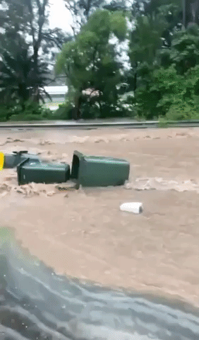 Garbage Bins Float Down Street During Flash Flood