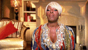 Reality TV gif. In a confessional, Nene Leakes from Real Housewives waves to the camera and sassily says, "Bye!" which appears as text, shutting her eyes and pursing her lips.