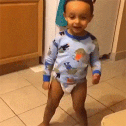 Video gif. A toddler in a diaper dances by shaking his legs and twirling his arms