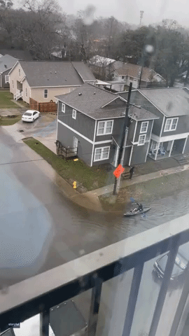 Kayaker Makes Way Along Flooded Street Near LSU