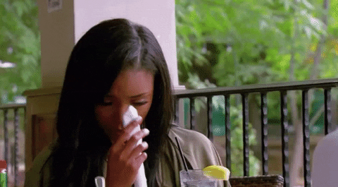 Reality TV gif. Woman on Basketball Wives babs her eyes gently with a napkin as she cries.
