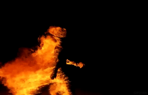 Movie gif. A person on fire in Daft Punk's Electroma walks in the pitch dark. The flame is huge and comes off every part of their body, behind them as they walk. It's a perfect loop. 