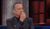 Celebrity gif. Tom Hanks on the Late Show cradles his chin in his hand as if contemplating something.