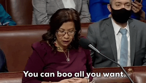 Political gif. Congresswoman Norma Torres stands in behind a microphone as she raises her hands as if indifference. Text, "You can boo all you want."