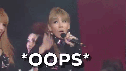 Celebrity gif. CL from Korean Pop group 2NE1 is singing and dancing on stage. She puts her hand to her lip and looks upwards, pretending to be shocked. Text, "Oops!"