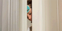 Movie gif. Audrey Hepburn as Holly in Breakfast at Tiffany's wears an eye mask as she pokes her head out a door with sleepy eyes closed.