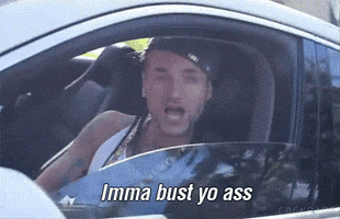 Celebrity gif. From the driver's seat and with the window down, Riff Raff glares menacingly at us and says, "Imma bust yo ass," which appears as text.