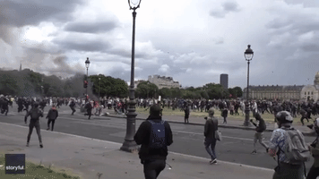 Police Officers Drag Wounded Colleague Under Barrage of Debris in Paris Protest