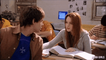 Movie gif. Lindsey Lohan as Cady in Mean Girls sits at a desk as Jonathan Bennet as Aaron Samuels turns around from his school desk with an inquiring expression on his face. Cady looks back at him with a shy expression, looking totally in awe of his beauty, as text appears. "It's October Third." 