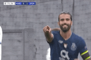 Sports gif. Sérgio Oliveira smiles and runs in our direction with his finger pointed at us. Text, "You!"