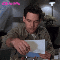 Movie gif. Annoyed by the interruption, Paul Rudd as Josh in Clueless looks up from reading a document.
