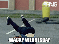 Celebrity gif. A bandmate from Travis band falls over with his guitar and rolls onto his back.