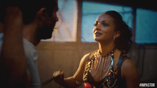 bdsm scene from impastor where a man is tied up and a woman puts a gag on him