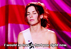 Movie gif. Sandra Bullock as Gracie in Miss Congeniality stands on stage at a pageant and says, “I would so love to hurt you right now.”