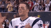 Sports gif. Tom Brady claps and cheers, raises his hands and shouts "let's go."