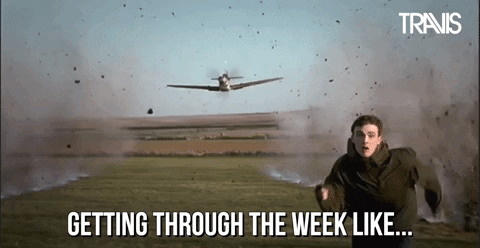 Video gif. A man runs away in terror from a fighter plane in the sky that’s shooting at him. The ground smokes as bullets hit the ground in a straight line. Text, “Getting through the week like…”