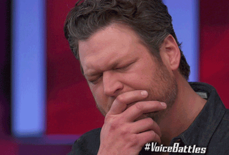 TV gif. Musician Blake Shelton holds his hand over his mouth in pensive thought from his judge's seat on The Voice.