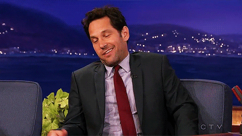 Celebrity gif. Paul Rudd wears a suit while being interviewed and he leans back in the sofa with a comedic unimpressed expression on his face while shrugging and waving a hand dismissively.