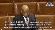 Political gif. Rep. John Lewis speaks on the floor of Congress. He stands in front of the podium and says, "On March 7, 1965, peaceful nonviolent protestors attempted to march from Selma, Alabama to the state capitol in Montgomery."