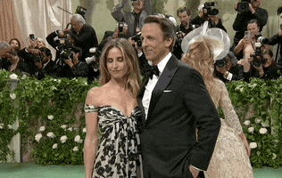 Met Gala 2024 gif. Seth Meyers and his wife Alexi Ashe pose for the cameras, amenable but bored.