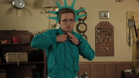 News MEI - Edição 20 - GIF de homem com a coroa da estátua da liberdade, mostrando a camiseta com a escrita: I love NY.