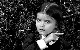TV gif. Lisa Loring as Wednesday Addams from the Addams Family drags her finger across her neck in a slightly threatening way
