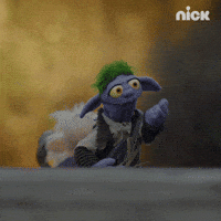 TV gif. Evan the Troll from The Barbarian and the Troll blows us a cheesy kiss before turning around and slowly walking away.