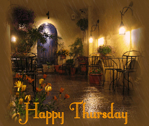 Video gif. Rain falls over an outdoor cafe lit by delicate lamps. Text, "Happy Thursday."