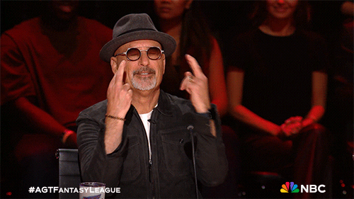 Reality TV gif. Howie Mandel on America's Got Talent crossing his fingers with both hands and bowing his head, praying for luck.