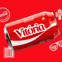 Sponsored gif. A red can of Coca-Cola with the name "Vitoria" spins horizontally. Coca-Cola logos on bottle caps and sunglasses are in the background.