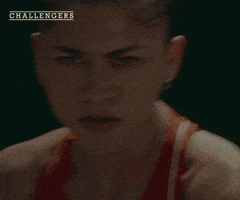 Movie gif. A shot from the movie "Challengers." Tashi Donaldson stands on a tennis court, holding a racket. She quickly hits a tennis ball, it flies forward. She has a serious expression. 