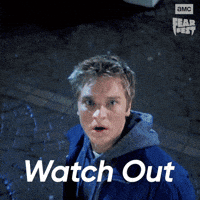 Sponsored gif. Man lunges and pushes another man out of the way before a massive sign can crush him. Sparks explode as it makes contact with the ground. In the upper right corner is the AMC Fear Fest logo. Text reads, “Watch out.”