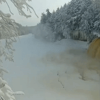 Water Flows Over Falls in Frozen Michigan Landscape