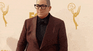 Celebrity gif. Lea Delaria from Orange Is The New Black triumphantly pumps her fist towards the ground and yells in celebration at the Emmys' red carpet.
