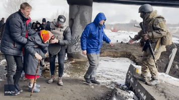 Ukrainian Civilians Cross River Near Destroyed Bridge as Evacuations Continue in Irpin