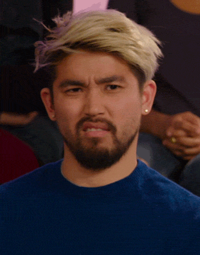Video gif. A young man with a goatee looks at us with a judgmental frown and shakes his head.