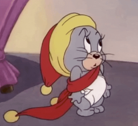 TV gif. Cartoon Jerry of Tom and Jerry is dressed in a diaper and festive red hat with matching scarf. He gestures into his wise open mouth to ask for food then licks his chops and rubs his belly in anticipation.