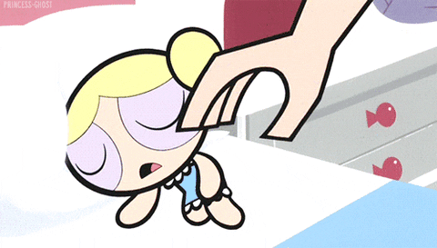 Cartoon gif. Hand places an octopus stuffed animal in the arms of a sleeping Bubbles from The Powerpuff Girls. Without waking up, she hugs the octopus tightly and smiles contentedly.
