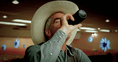 Movie gif. Sam Elliot as the Stranger in The Big Lebowski sits at a bar and takes a big drink from a beer bottle. He swallows the drink and looks out the corner of his eye as he says, “Thankie.”