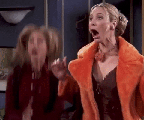Friends gif. Lisa Kudrow as Phoebe and Jennifer Aniston as Rachel jump up and down, smiling and clapping their hands exuberantly at something offscreen. 