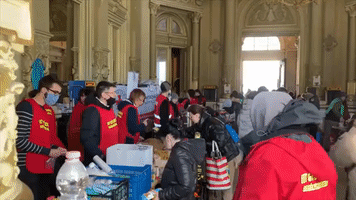 Volunteers Help Ukrainian Refugees Arriving in Budapest Train Stations