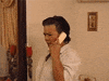 Video gif. Woman is on the telephone and she looks up at us with utter shock on her face as her jaw drops open and her eyes widen. The camera zooms in on her.