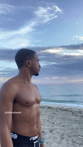 Playing A Conch Shell at Sunrise On The Beach