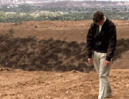 Arrested Development gif. Michael Cera as George Michael Bluth trudges through a desert area with his head down and shoulders hunched forward.