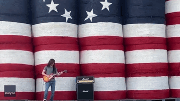 Man Plays National Anthem in Front of Flag