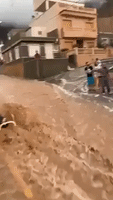 Floodwater Surges Down Street in Spanish Town After Deluge