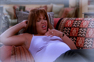 TV gif. A scene from My Wife and Kids. Damon Wayans looks shocked as he catches a baby in his arms after a pregnant woman lying on the couch, coughs.