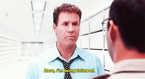 Movie gif. Will Ferrell as Harold Crick in Stranger Than Fiction stiffly whispers to a coworker "Dave, I'm being followed," who glances puzzledly around the very empty room.